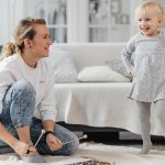 A joyful moment of a mother and daughter playing with a xylophone in a cozy living room.
